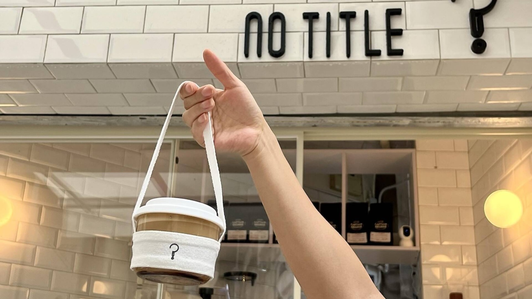 A No Title drink in a reusable glass cup with a strap